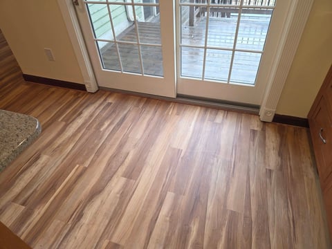 Interior room with laminate wood flooring and glass patio doors overlooking a deck